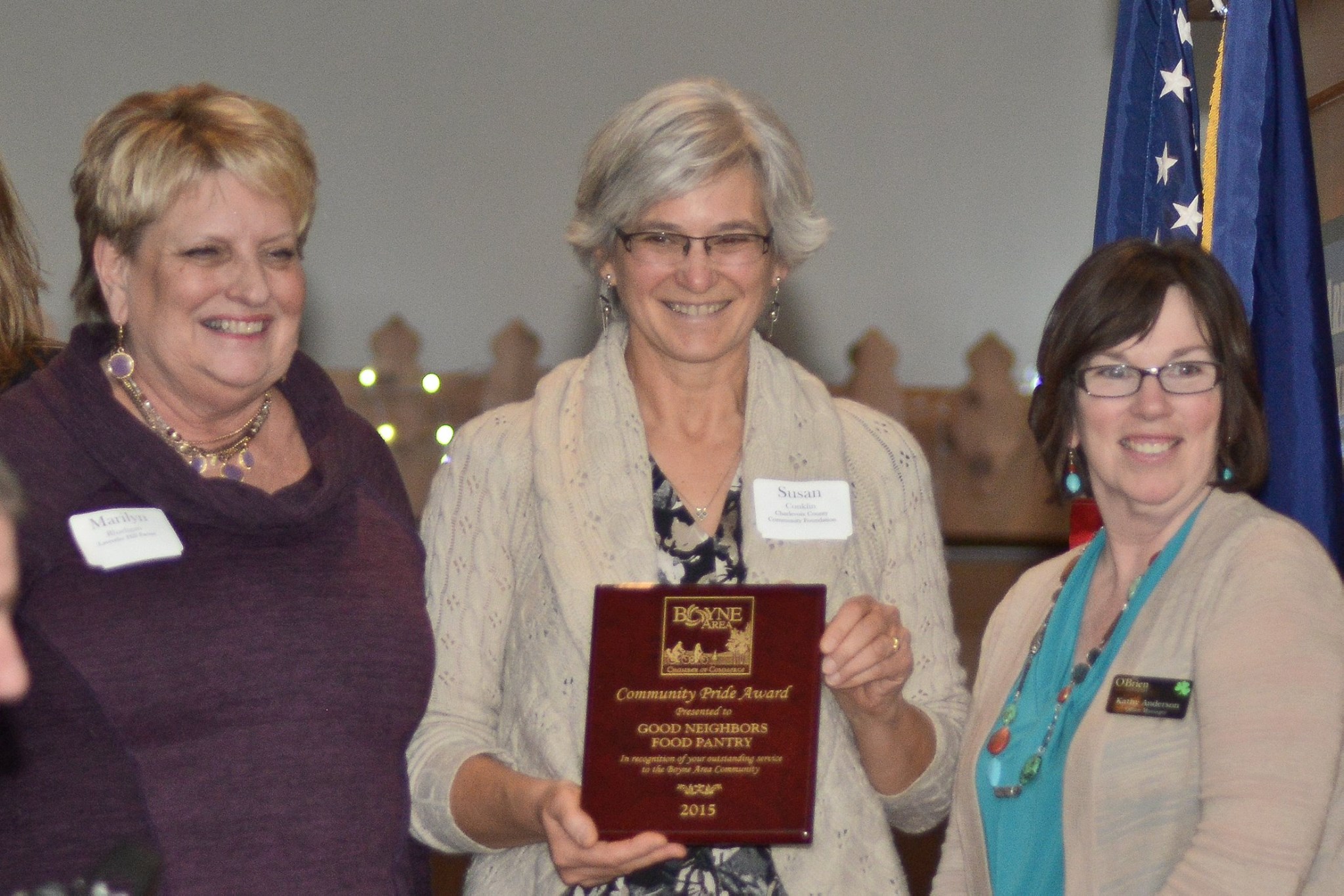 Three women holding Community Pride Award